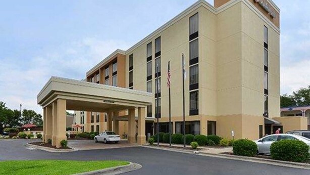 A modern hotel with a covered entrance, multiple floors, and a flagpole. - Comfort Inn Elizabeth City near University (Elizabeth City)