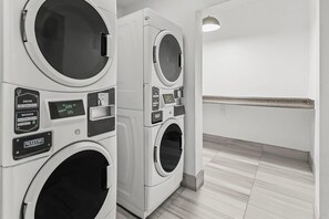 A commercial laundry facility with multiple washing machines, control panels, and a tiled floor. - Comfort Inn Elizabeth City near University (Elizabeth City)