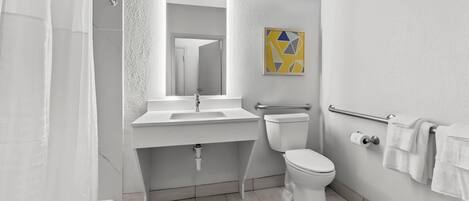 Un baño moderno con ducha, inodoro y lavamanos.