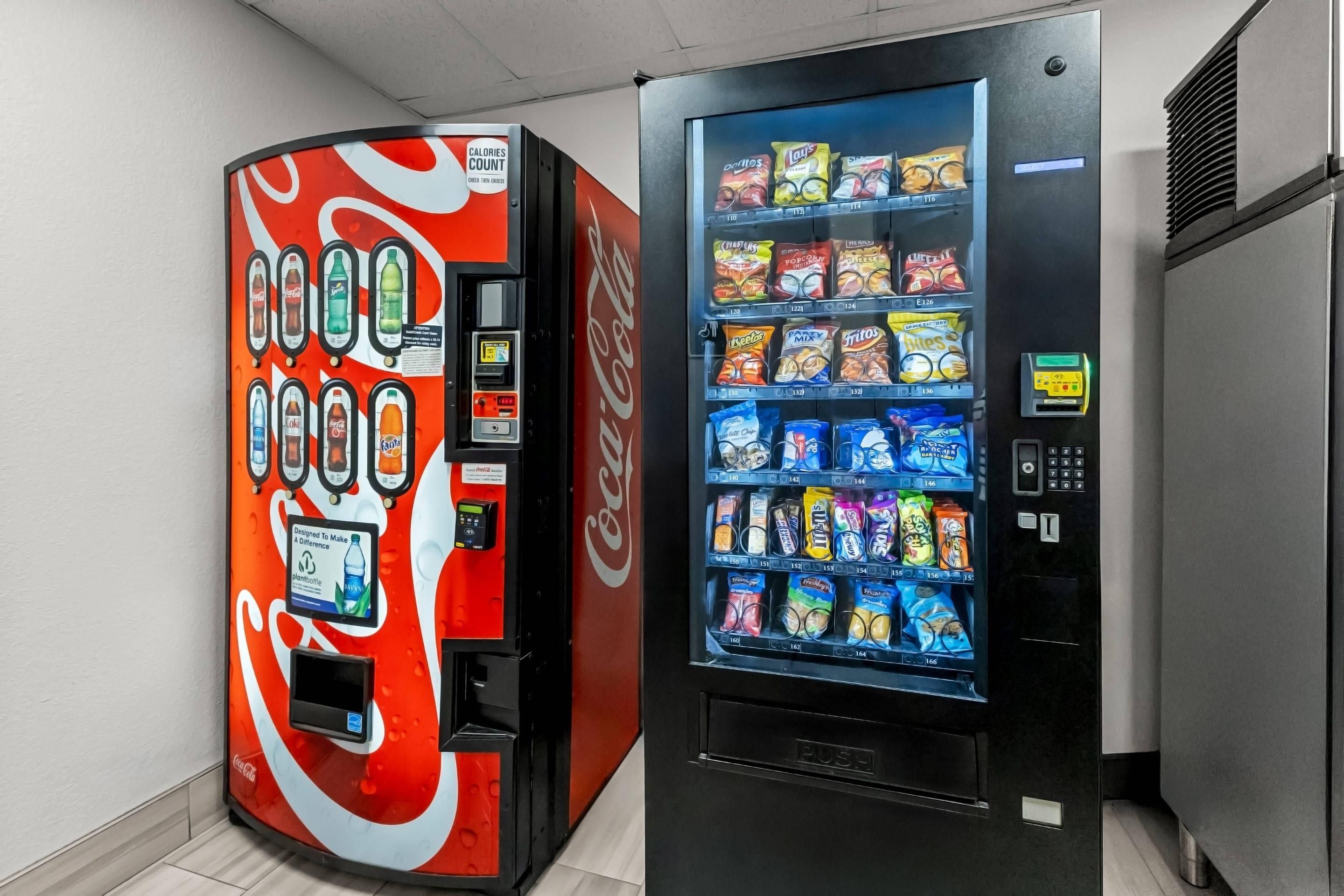 Two vending machines, one with a Coca-Cola logo and the other with a snack selection.