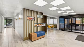 Een modern interieur met een receptiebalie, een wanddisplay en een zithoek.