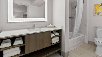 A modern bathroom with a white sink, mirror, and shower.