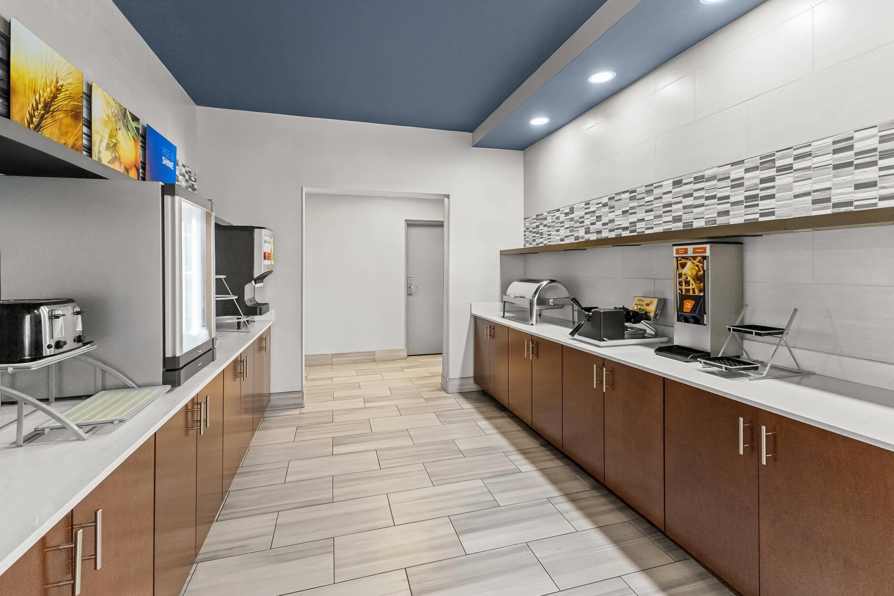 Una cocina moderna con una isla central, una cafetera y un fabricante de gofres.