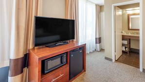 A hotel room with a television on a wooden cabinet, a microwave, and a small refrigerator. - Comfort Inn Elizabeth City near University (Elizabeth City)