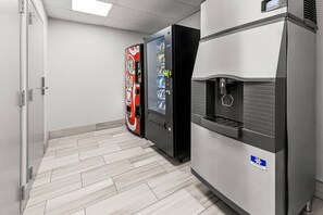 A vending machine and a water dispenser in a hallway with a tiled floor. - Comfort Inn Elizabeth City near University (Elizabeth City)