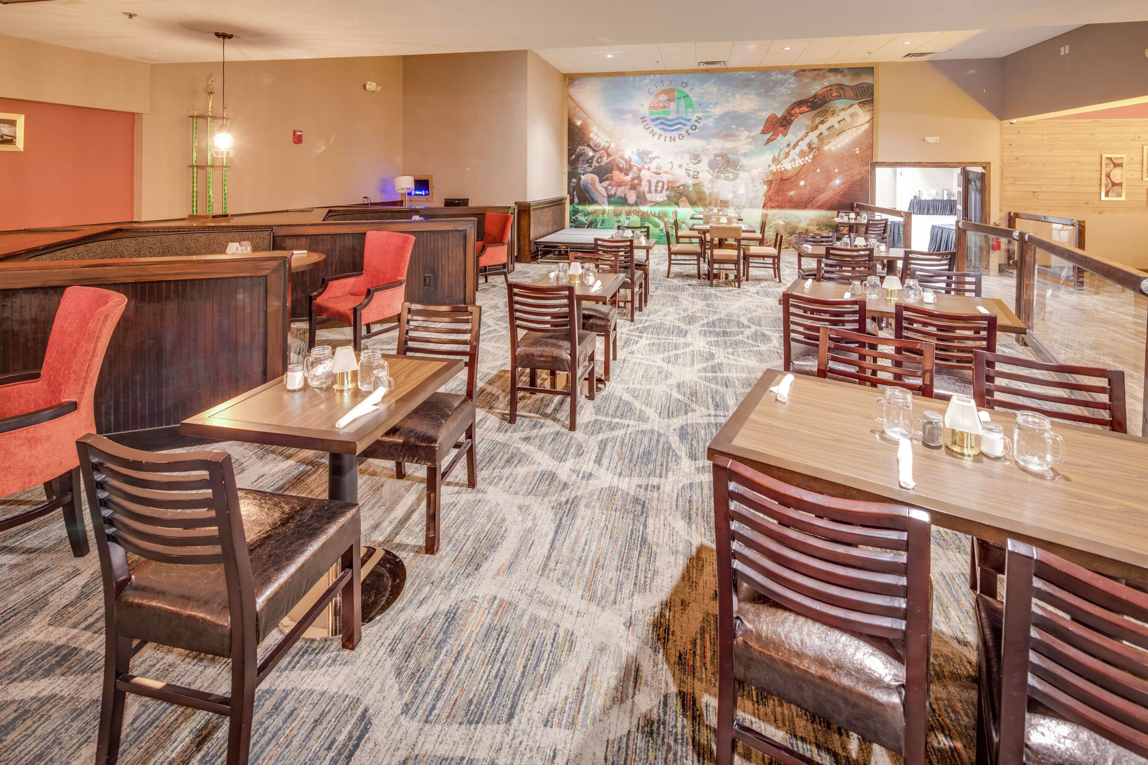 A restaurant with booths and tables, carpeted flooring, and a mural on the wall.