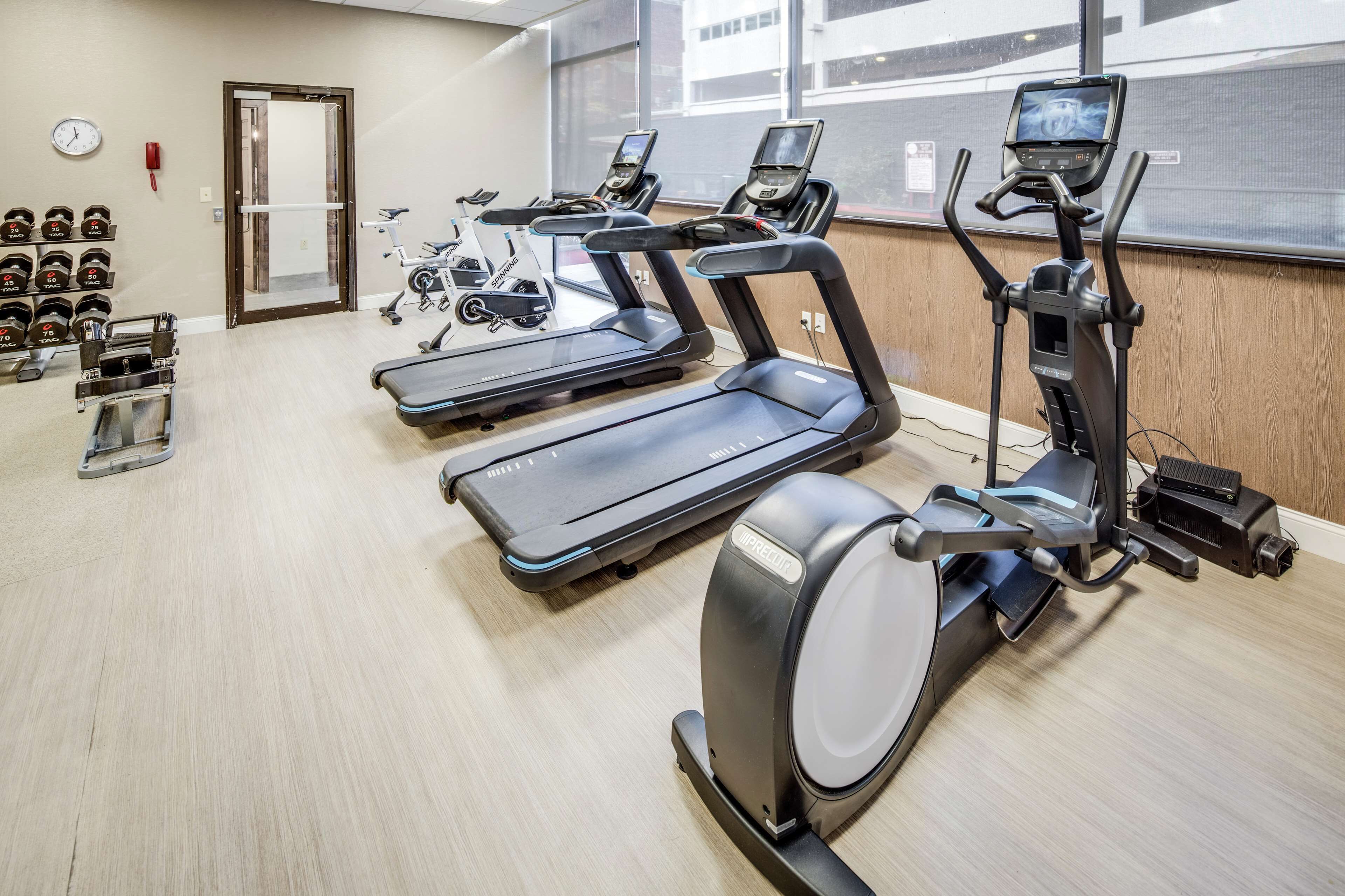 A gym with treadmills, elliptical machines, and weight benches.