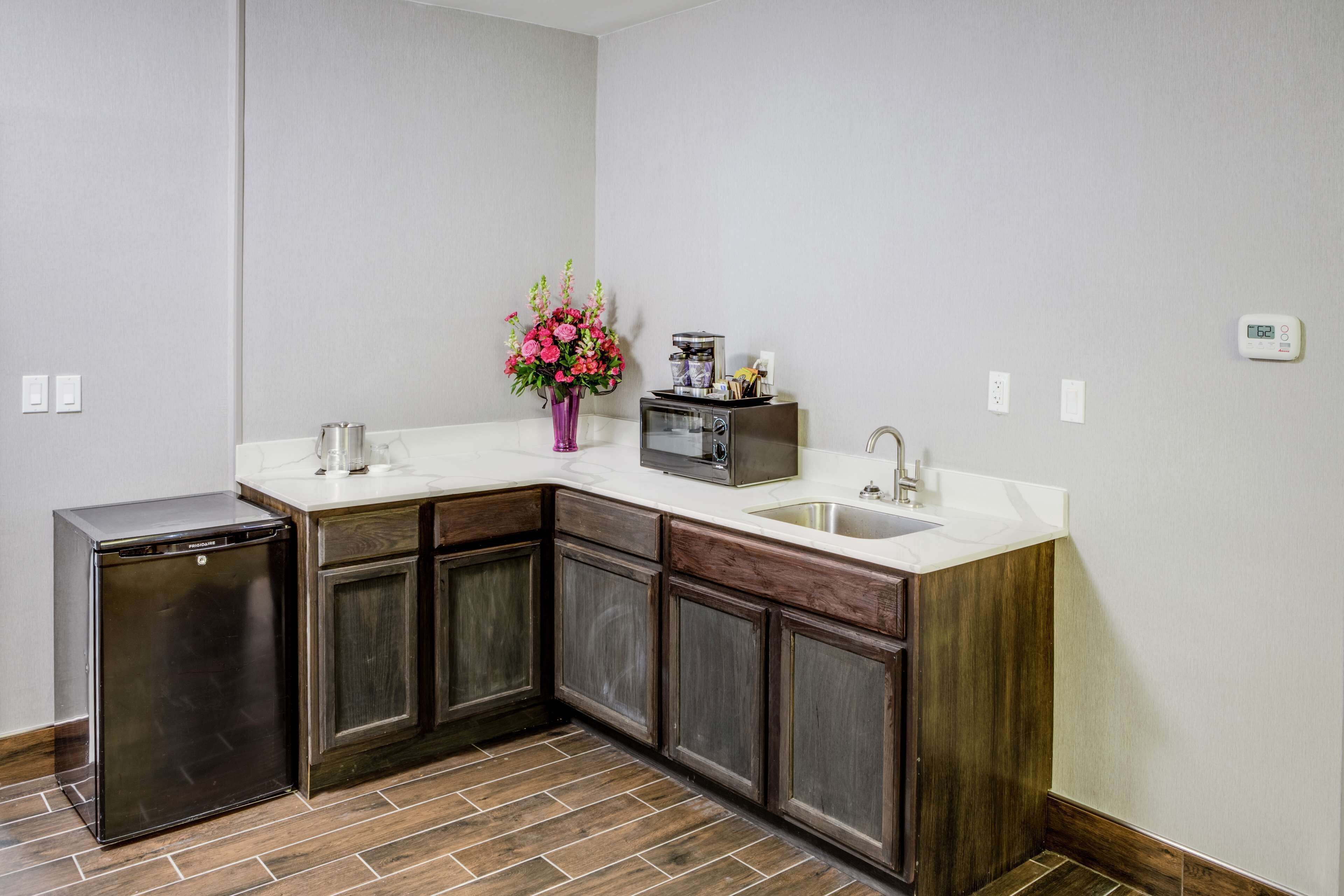 Una cocina con lavavajillas integrado, un lavabo y una cafetera sobre la encimera.