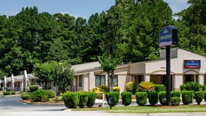 Un Howard Johnson Express Inn con un edificio de dos pisos, estacionamiento y jardines bien cuidados.