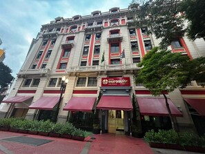 Un hotel con toldo rojo, un letrero que dice "Hotel Eurosuite São Paulo Centro" y una bandera.