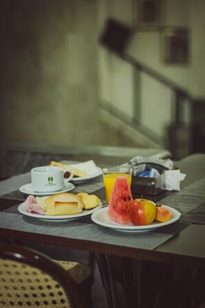 A breakfast table with plates of food, a cup, and a glass of juice. - Hotel Euro Suite São Paulo by Nacional Inn (São Paulo)