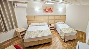 A hotel room with two beds, a wooden headboard, a bedside table with a phone, and a painting on the wall. - Hotel Euro Suite São Paulo by Nacional Inn (São Paulo)