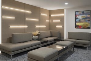 Una sala moderna con un sofá seccional, una mesa de centro e iluminación empotrada.