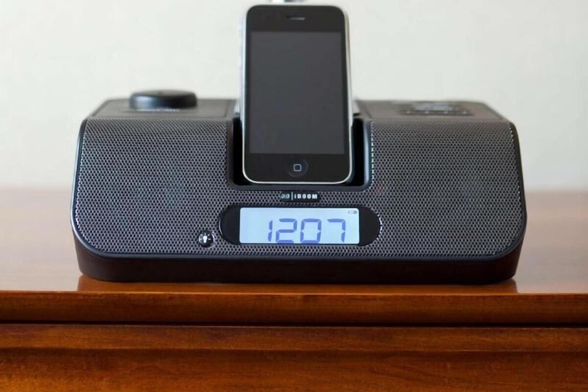 Eine digitale Uhr zeigt 12:07 auf einer Holzoberfläche.