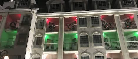 Un edificio de varios pisos con balcones, cada uno decorado con coronas.