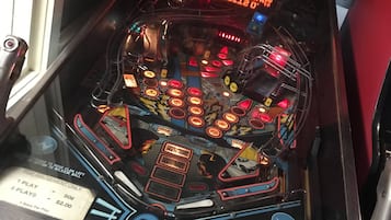 A pinball machine with a neon sign that reads "CREDITS O. INSERT COIN" and a label indicating "2 TOKENS".