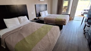 Una habitación de hotel con dos camas, un escritorio y una silla.