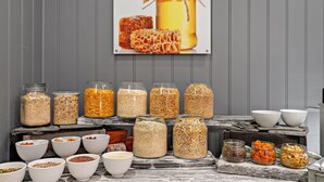 Una exhibición de alimentos con frascos y recipientes de diversos cereales y semillas.