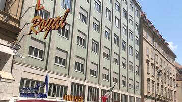 Um hotel com vários andares e uma placa de destaque com a inscrição 'HOTEL ROYAL'.
