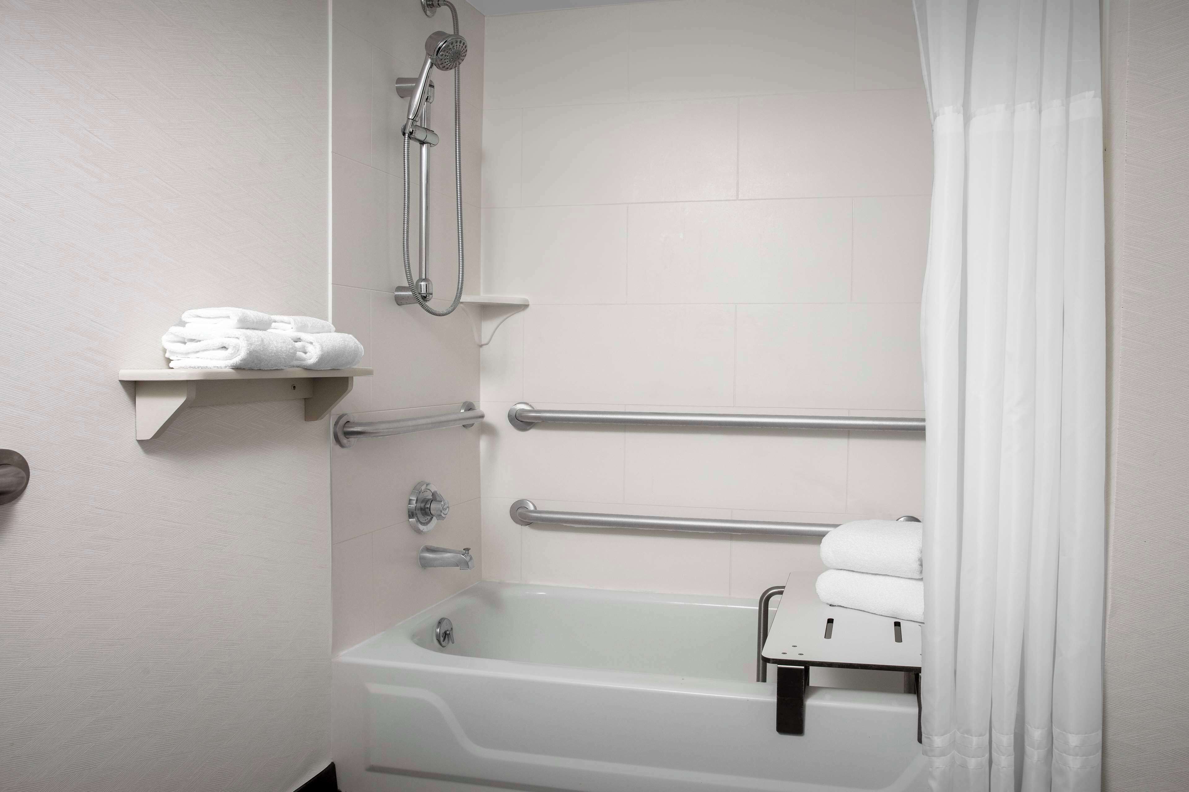 A bathroom with a bathtub, a shower, and a towel rack.
