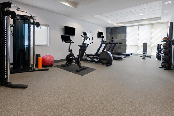 A gym with cardio machines, weightlifting equipment, and exercise balls. - Home2 Suites by Hilton Dover, DE (Dover)
