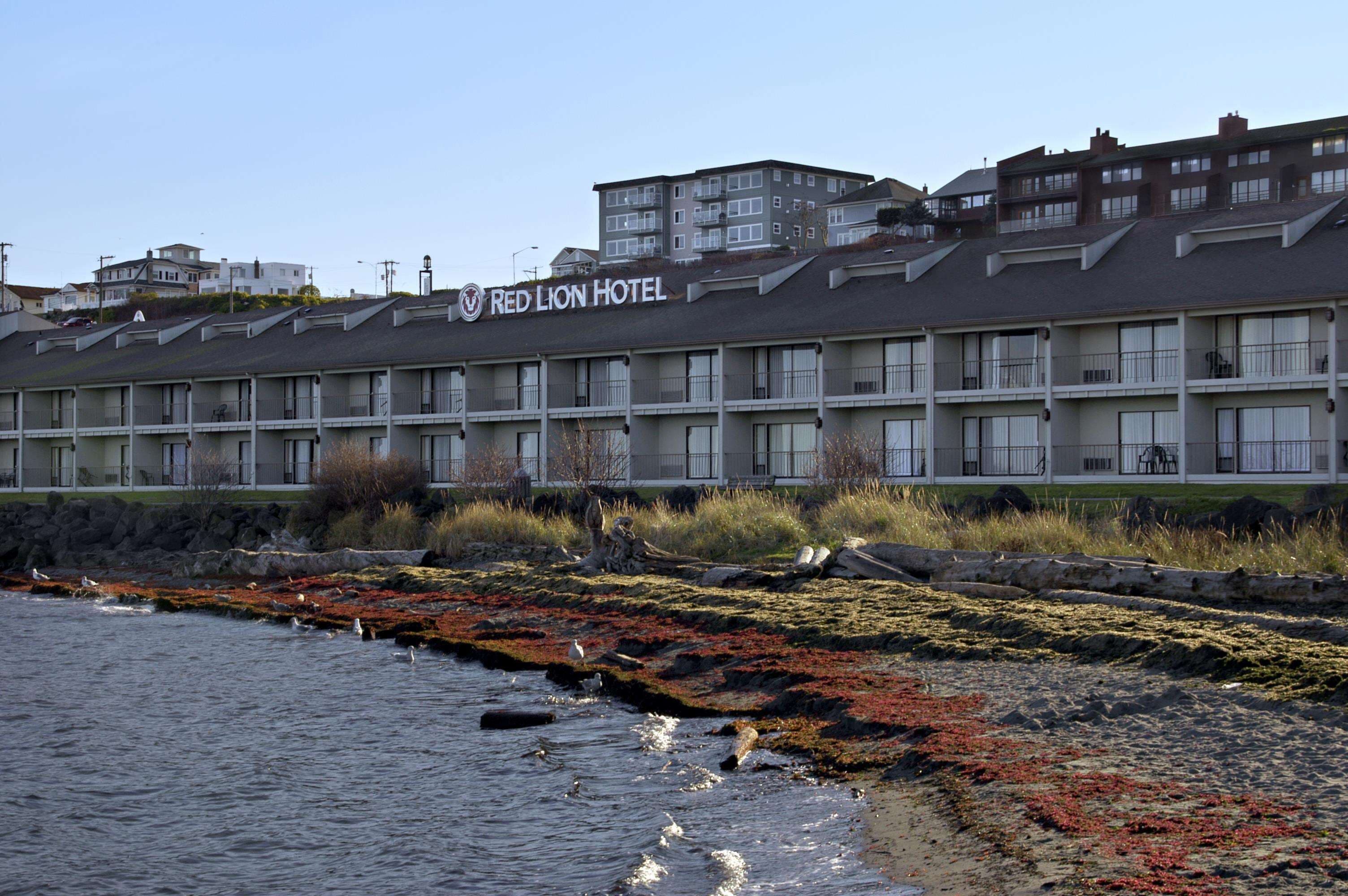 Ett Red Lion-hotell med ett platt tak, flera balkonger och utsikt över vattnet.
