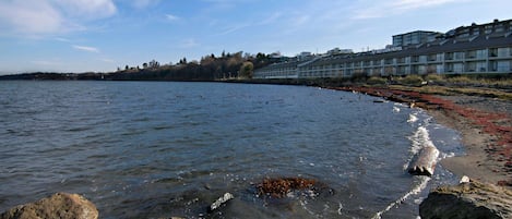 A waterfront hotel with a view of the water and a rocky shoreline.