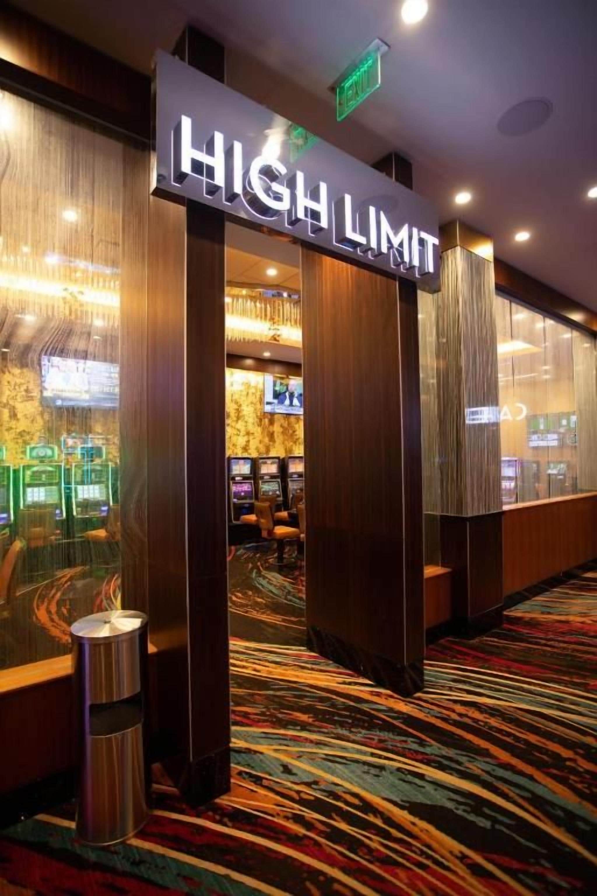 En hotelindgang med et skilt, der viser 'HIGH LIMIT', et tæppe og et syn på spillemaskiner.