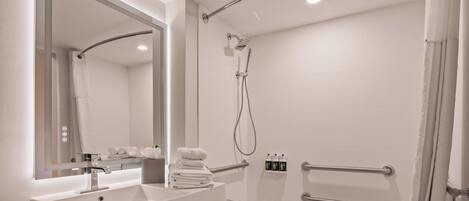 Une salle de bain moderne avec un lavabo blanc, un miroir et une douche.