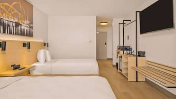 Quarto de hotel moderno com duas camas, uma escrivaninha, televisão de tela plana e um quadro de uma ponte.