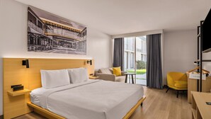 A modern hotel room with a large bed, a desk, a chair, and a window with curtains. - B&B Hotel Orlando International Drive Near Universal - Newly Renovated! (Orlando)