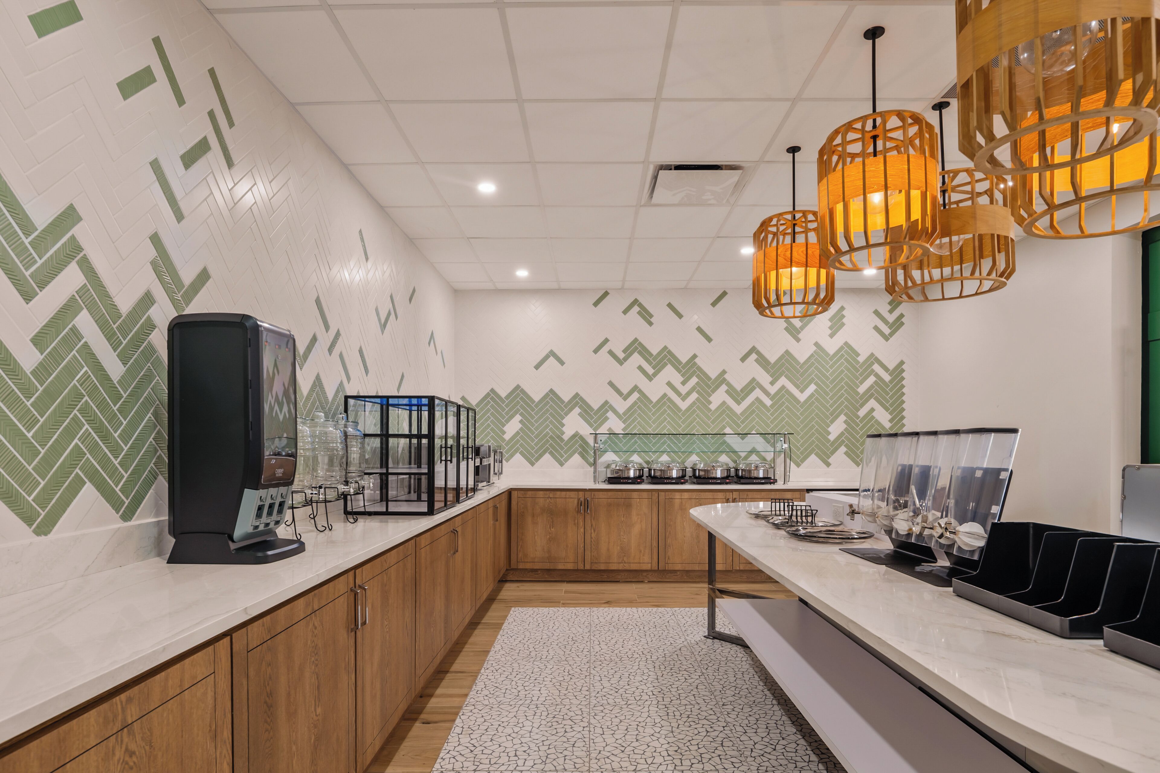 A modern kitchen with wooden cabinets, a coffee machine, and a counter with glassware.