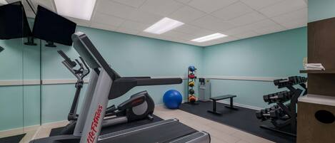 A gym with treadmills, exercise balls, and weight machines.
