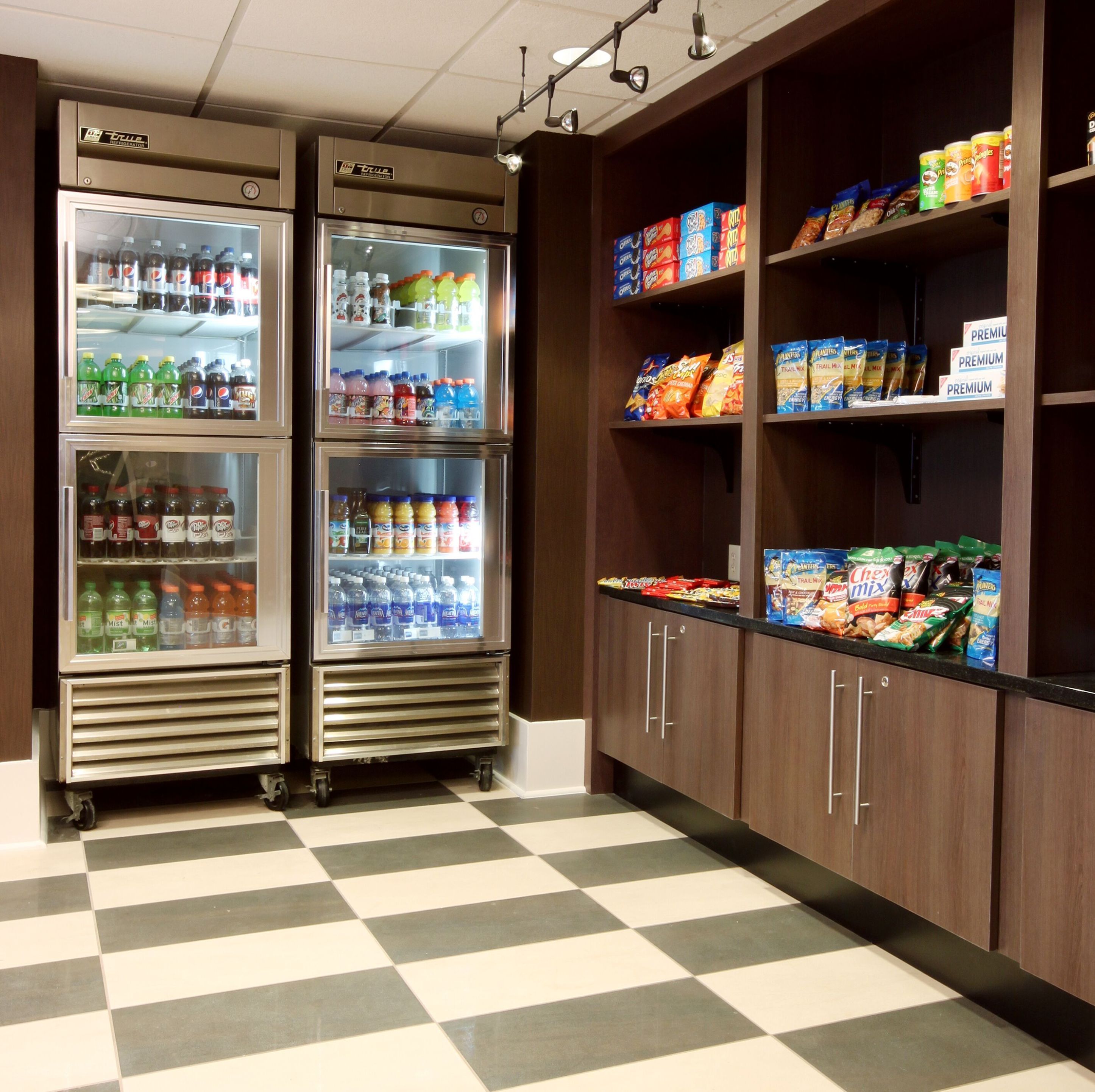 En automatsektion med kølede drikkevarer og hylder med snacks.