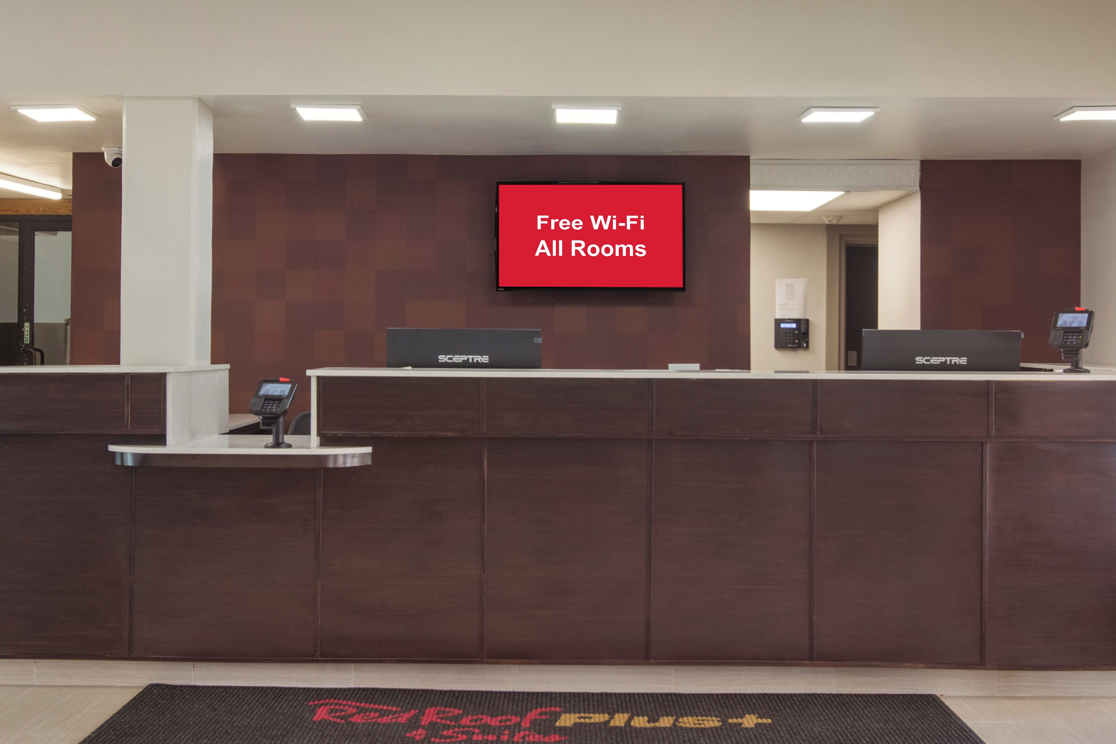 Un comptoir d’accueil doté d’un écran numérique affichant la mention : « Wi-Fi gratuit dans toutes les chambres ».