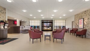 A spacious lobby with a reception desk, seating area, and a view through a glass door. - Red Roof Inn PLUS+ & Suites Erie (Erie)