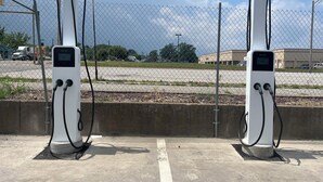 Two electric vehicle charging stations with a chain-link fence in the background. - Red Roof Inn PLUS+ & Suites Erie (Erie)