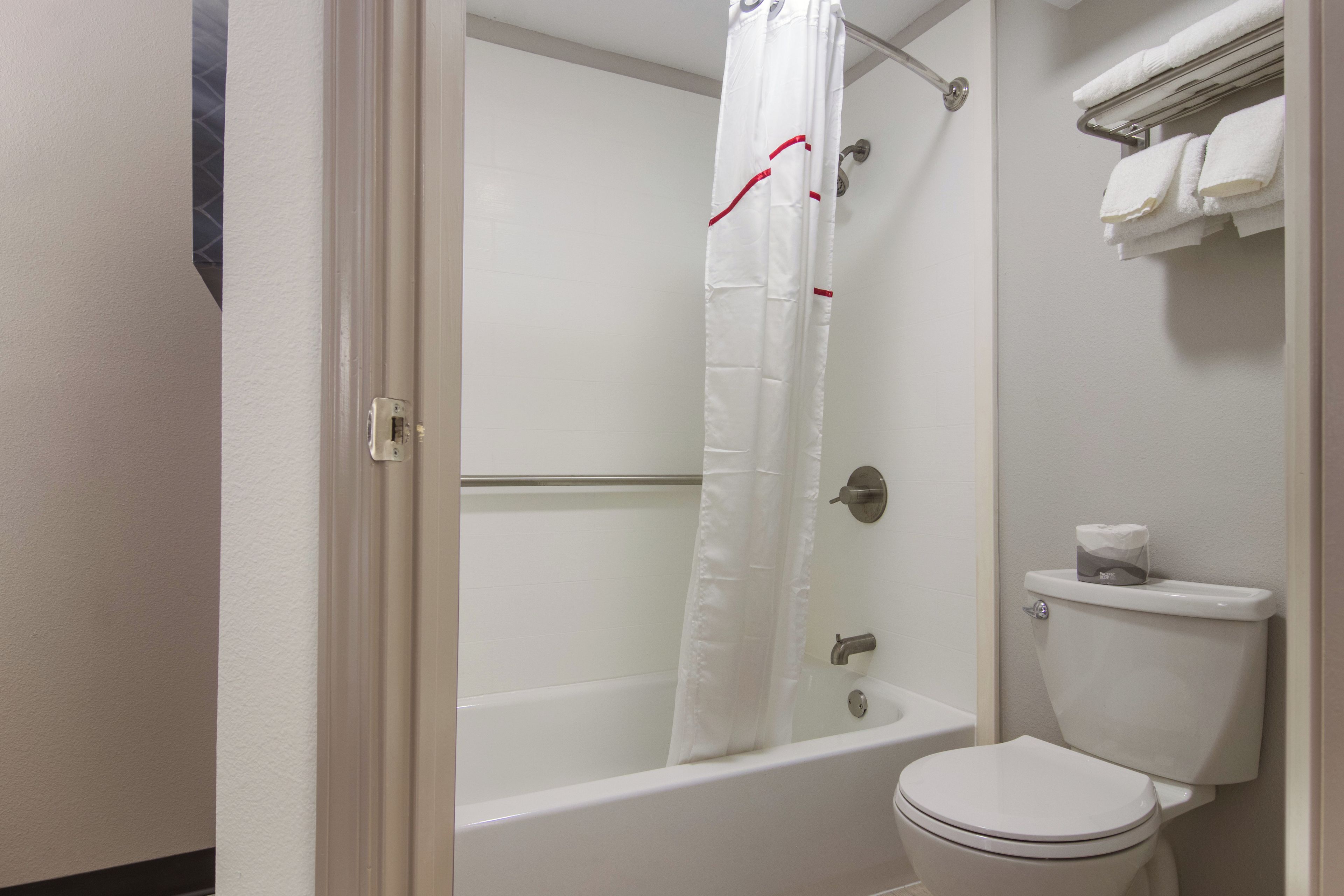 Une salle de bain avec une baignoire, des toilettes et un rideau de douche.