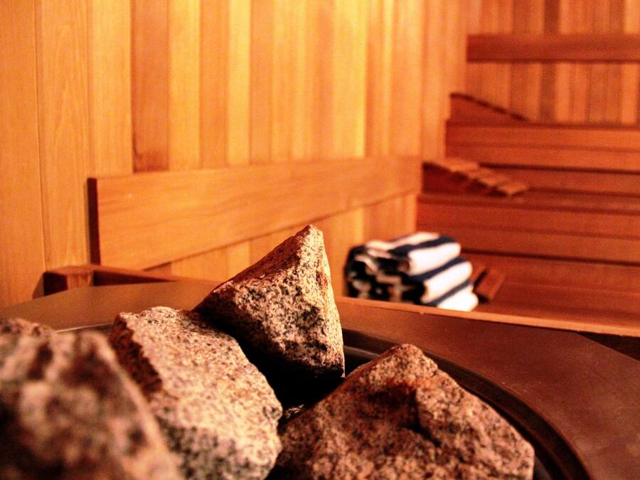 A wooden headboard with a stack of folded towels and a tray with rocks.