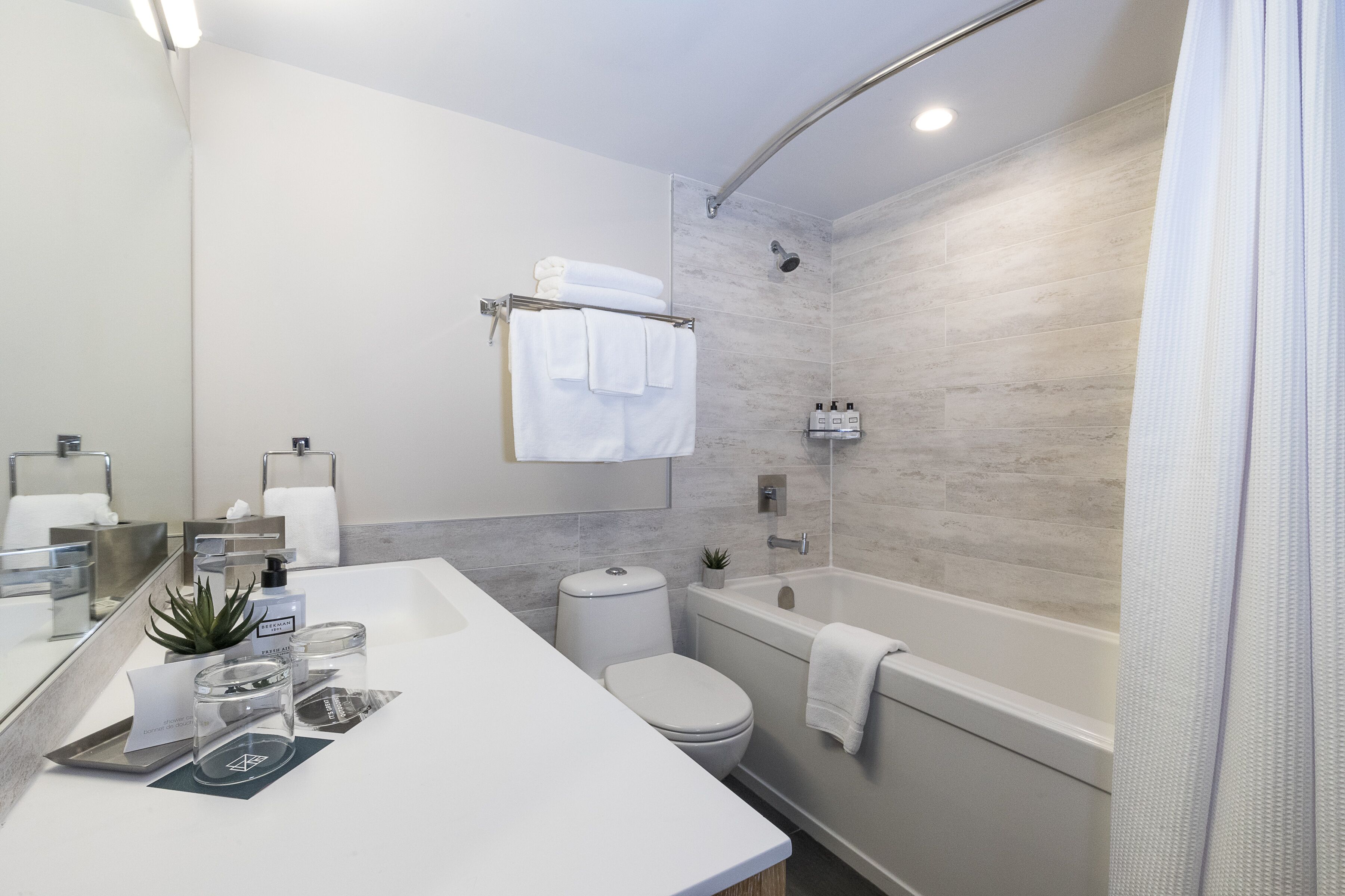 Un baño moderno con lavamanos blanco, inodoro, bañera y ducha.