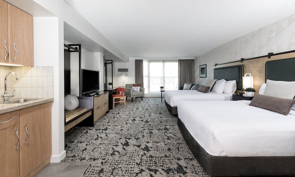 A hotel room with two beds, a desk, a TV, a minibar, and a bathroom. - Crystal Lodge (Whistler)