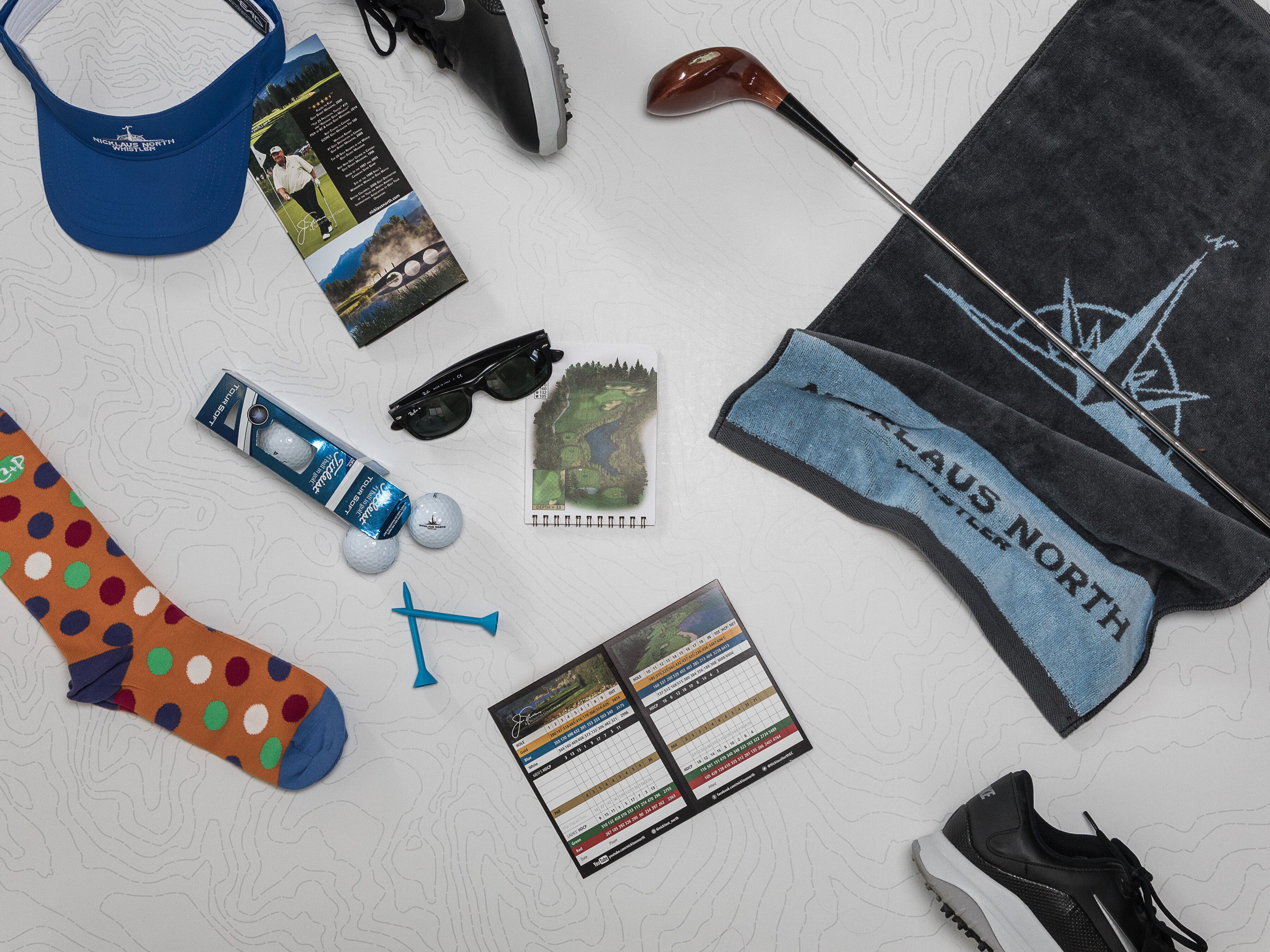 A collection of golf-related items including a cap, golf club, golf balls, a golf bag, a pair of sunglasses, a golf glove, a golf club bag, a golf tee, a golf bag strap, and a golf scorecard.