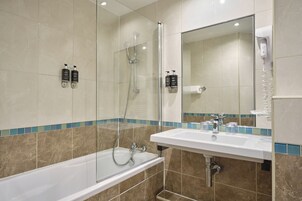 Un bagno moderno con una vasca, una doccia, un lavandino e uno specchio.