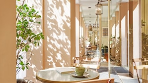A cozy cafe with a round table, a green cup, and a book.