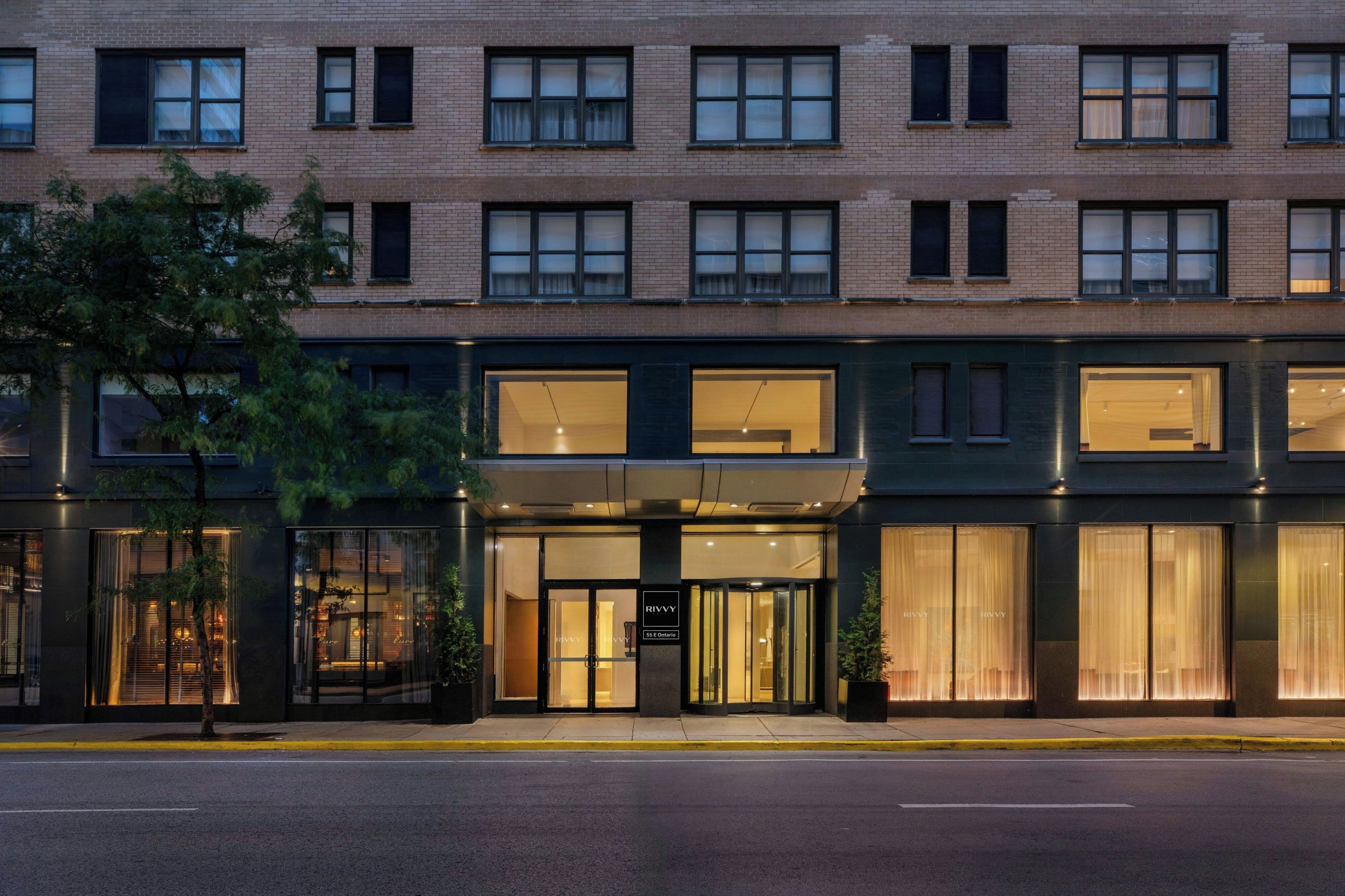 A multi-story hotel with a modern facade, large windows, and a well-lit entrance.