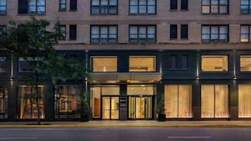 Un hotel de varios pisos con fachada moderna, amplias ventanas y una entrada bien iluminada.