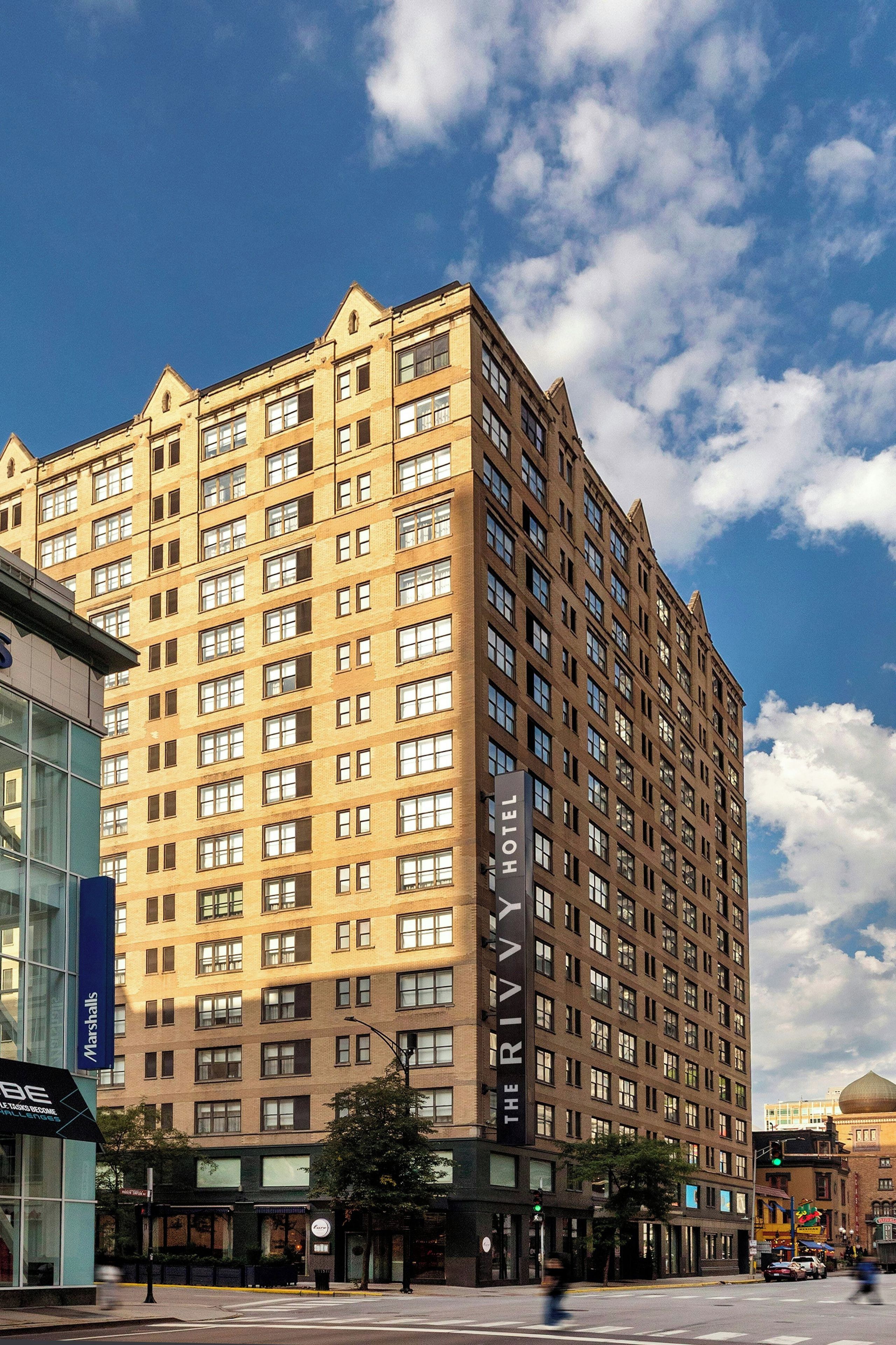 A multi-story hotel with a prominent 'HOTEL' sign on the facade, featuring a classic architectural design with a flat roof and numerous windows.