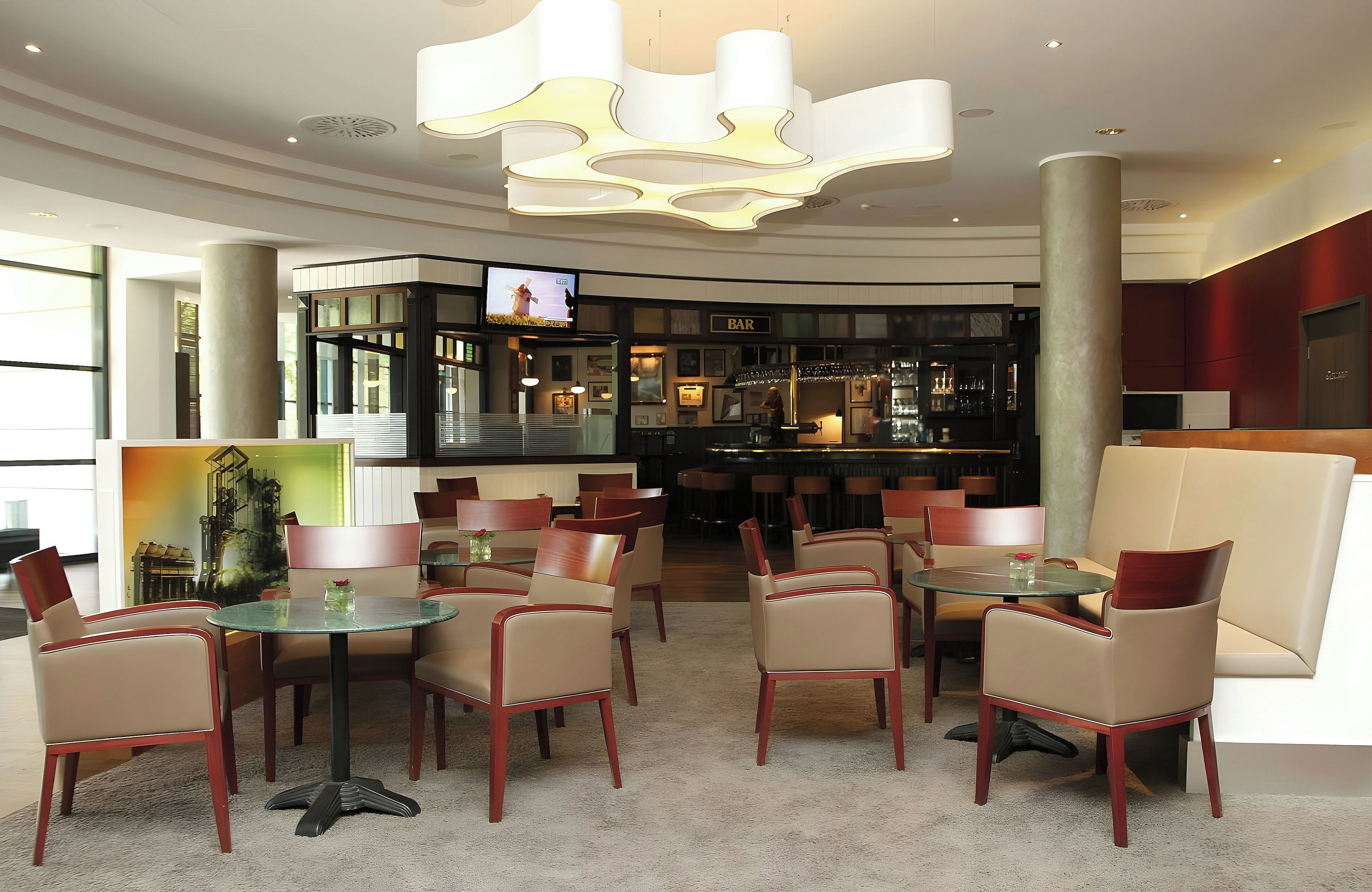 Een moderne bar met zitplaatsen en een televisiescherm.