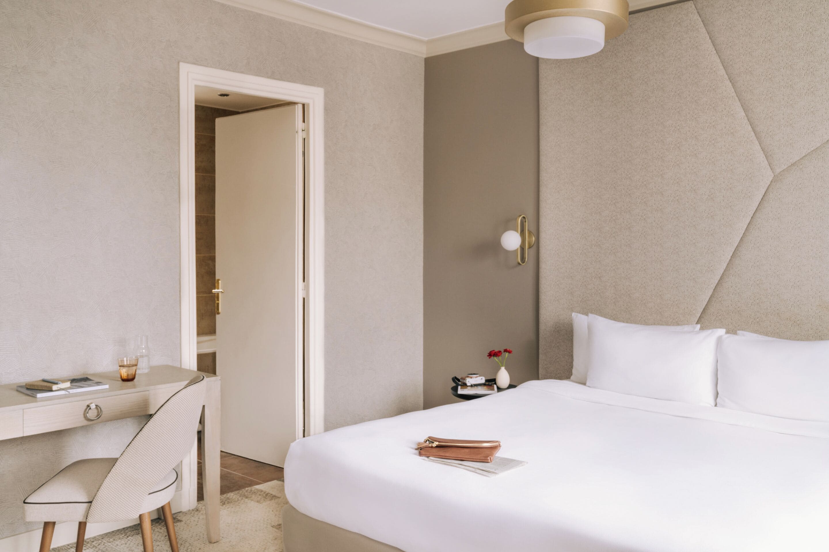 Una habitación de hotel con una cama, un escritorio y una silla.