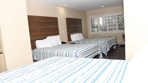 Een hotelkamer met twee bedden, een raam met zonwering en een houten hoofdeinde.
